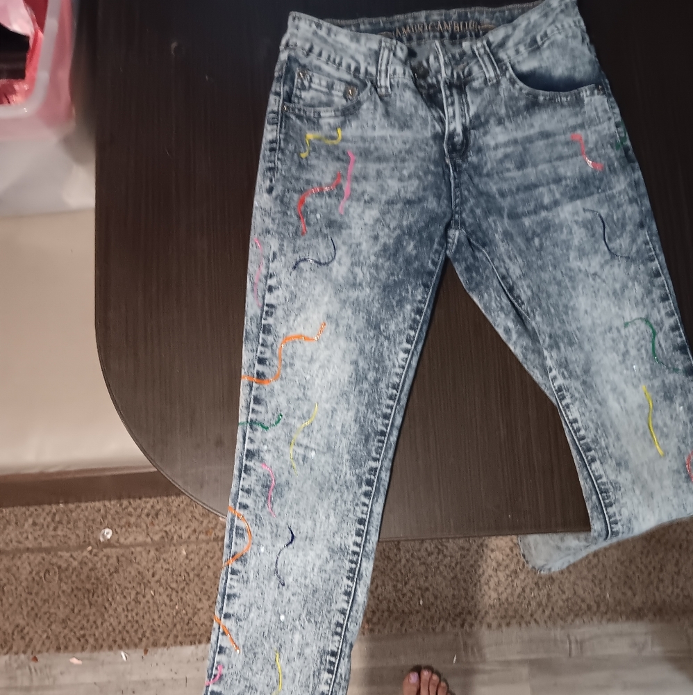 Cute blue jeans that are hand painted.